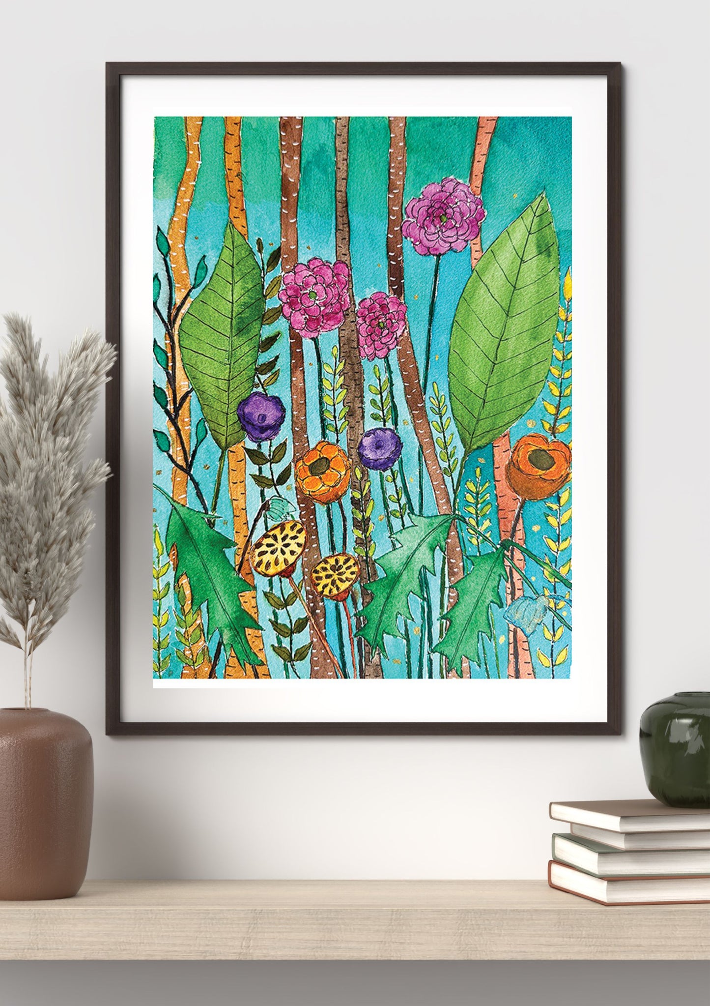 A framed botanical art print featuring colorful wildflowers and leaves on a teal background, styled on a light wood shelf with a vase and books against a white wall.